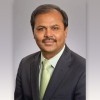 Dr. Suresh Ramalingam wearing a suit and tie