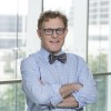 Eric Bernicker with his arms crossed wearing a blue shirt and bow tie