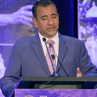 Luis Raez speaking at podium